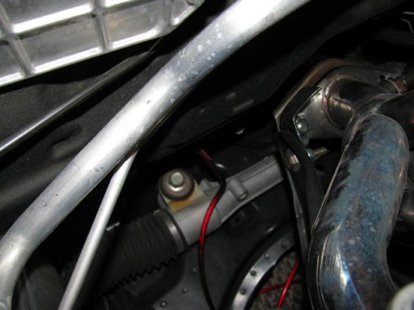 Sorry for the dark photo, but this is the power lead coming out from the rubber gromet next to the A/C vent line in front of the firewall.