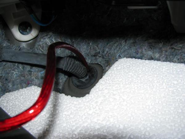 Close up of the power lead inserted into a hole in the A/C vent grommet.